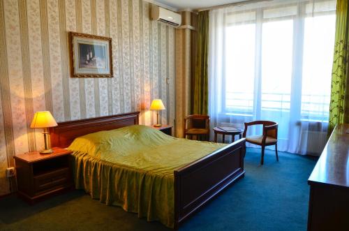 基辅Diplomat ApartHotel的酒店客房带床、椅子和窗户