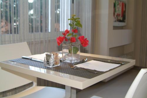 卡利亚里B&Beach Cagliari guest house的一张桌子,上面有红花花瓶
