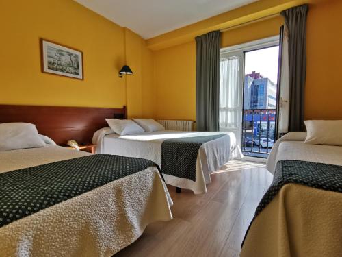 圣地亚哥－德孔波斯特拉圣雅各布酒店的酒店客房设有两张床和窗户。