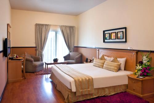 迪拜地标广场酒店的酒店客房带一张大床和一把椅子