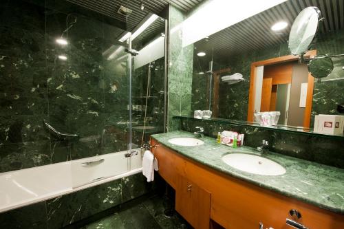 维多利亚-加斯特伊兹拉库阿大酒店的一间带两个盥洗盆和大镜子的浴室