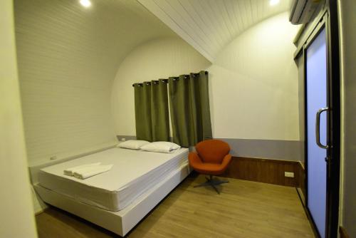 曼谷Tiny hut resort的小房间设有一张床和一把椅子