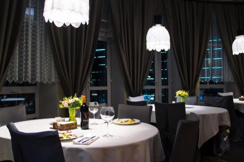 别洛库里哈布拉格达酒店的用餐室配有2张桌子和椅子及酒杯