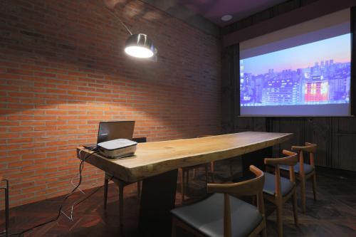 首尔阁楼精品酒店的一间会议室,内设一张桌子和一个投影屏幕