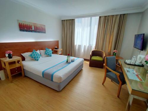 哥打京那巴鲁唐代酒店的酒店客房设有一张大床和一张书桌。