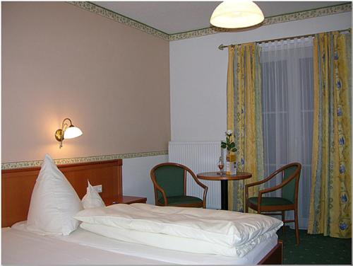 多瑙斯陶夫Landgasthof-Hotel Hammermühle的卧室配有一张床和一张桌子及椅子