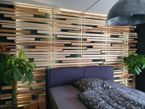 科特布斯Black & Wood Design FeWo im Zentrum的卧室在窗户前配有蓝色沙发