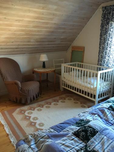 格兰耶德Nice stay in beautiful, calm environment的一间卧室配有一张床、一张婴儿床和一把椅子