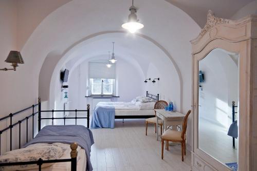 西维德尼察巴尔科萨卡提克旅馆的一间卧室配有两张床和一张桌子,桌子上配有四柱床。