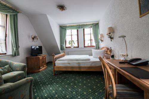 鲁尔河畔米尔海姆兰德萨森霍夫酒店的酒店客房配有一张床、一张书桌和一张书桌。