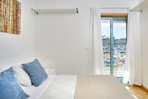 阿尔布费拉Casas Barulho Albufeira Marina的白色的卧室设有床和大窗户