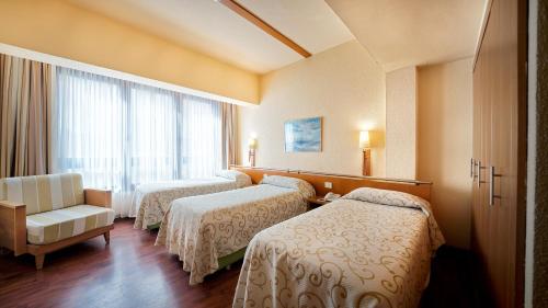 大加那利岛拉斯帕尔马斯Bull Astoria的酒店客房设有三张床和窗户。