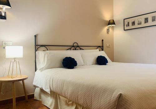 托莱多Alda Hospedería De Los Reyes的一间卧室配有白色床和蓝色枕头