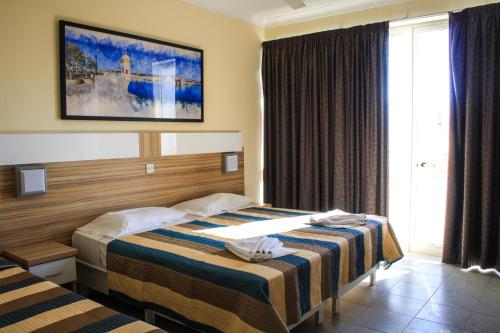 圣保罗湾城珊瑚酒店的酒店客房设有两张床和窗户。