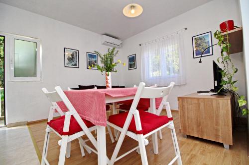波拉斯Apartments Nodilo的厨房以及带粉红色桌椅的用餐室。
