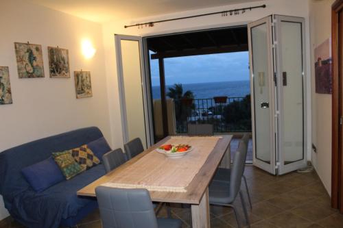 圣凯撒利亚温泉Christian casa vacanze Salento的一间带桌子和蓝色沙发的用餐室