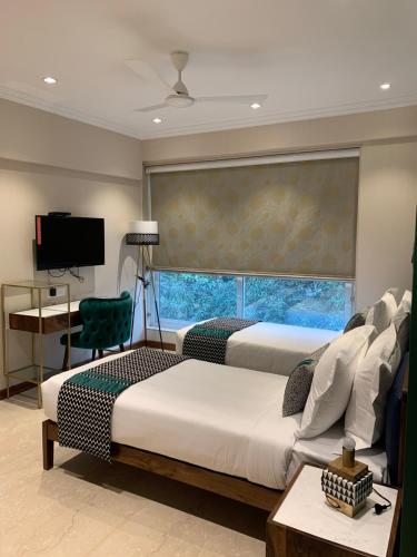 孟买Theory9 Premium Service Apartments Bandra的一间卧室设有两张床和大窗户
