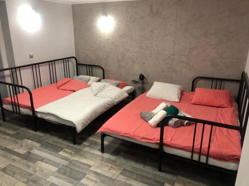 SpytkowiceFANTAZJA的配有红色和白色床单的客房内的两张床