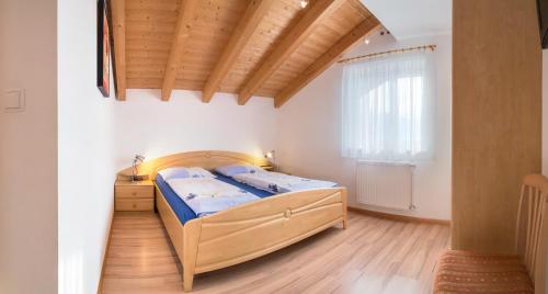 泰尔梅诺St. Urbanhof的一间卧室设有一张床和木制天花板