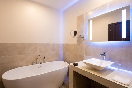 达喀尔Hotel L'Adresse Dakar的浴室配有大型白色浴缸和水槽