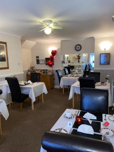 托基Crowndale Torquay - Exclusively for Adults的一间设有白色桌椅的用餐室和一间餐厅