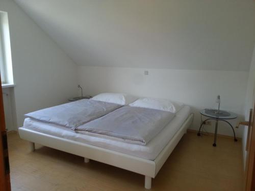 费尔德基希Appartement Feldkirch的一张白色的床,位于带桌子的房间