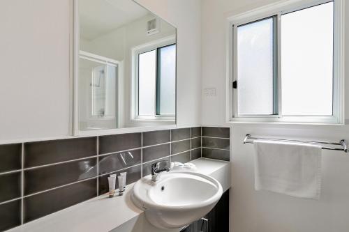 卡尔斯Kaloha Holiday Resort Phillip Island的白色浴室设有水槽和2扇窗户