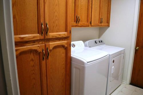三河城Blue Jay Paradise的厨房配有洗衣机和木制橱柜。