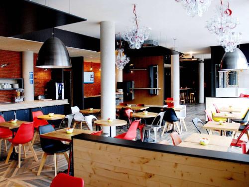 PoisyIbis Budget Annecy sud-Poisy的餐厅设有桌椅和吊灯。