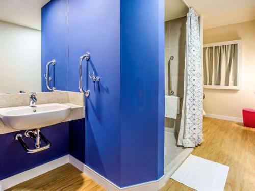 乌贝兰迪亚ibis budget Uberlandia的蓝色的浴室设有水槽和淋浴