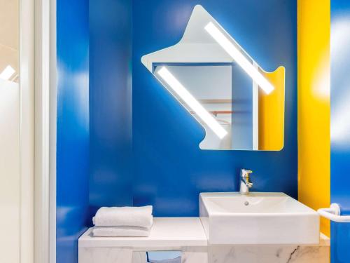 圣热尼普伊ibis budget Geneve Saint Genis Pouilly的蓝色的浴室设有水槽和镜子
