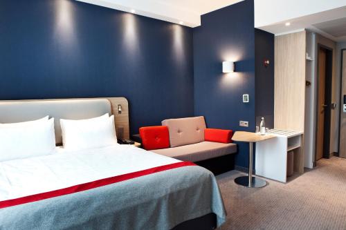 萨尔布吕肯Holiday Inn Express - Saarbrücken, an IHG Hotel的配有一张床和一把椅子的酒店客房