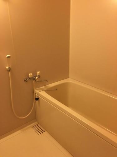 美作Yunogo Bishunkaku的带淋浴的浴室配有白色浴缸。
