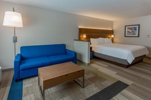 Rice LakeHoliday Inn Express & Suites - Rice Lake, an IHG Hotel的酒店客房,配有床和蓝色的沙发