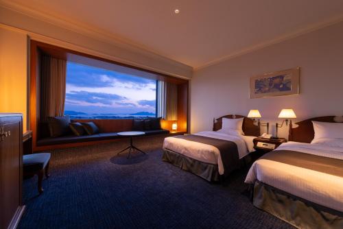 广岛广岛丽嘉皇家酒店的酒店客房设有两张床和大窗户。
