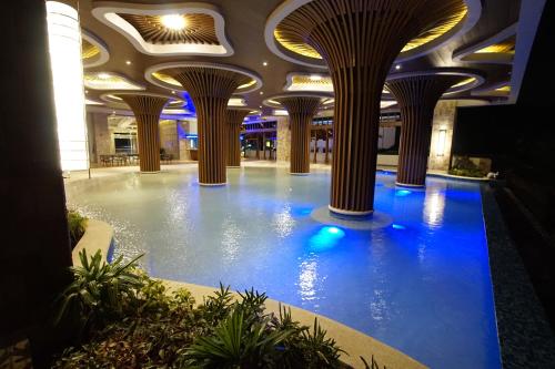 奥隆阿波Central Park Reef Resort的一座设有柱子的建筑里的大型室内游泳池