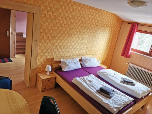 圣奥斯瓦尔德Pension Fernblick的一间卧室配有一张带紫色毯子的床和窗户。