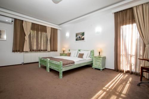 尼克希奇特里姆酒店的一间卧室设有床和两张桌子及窗户。