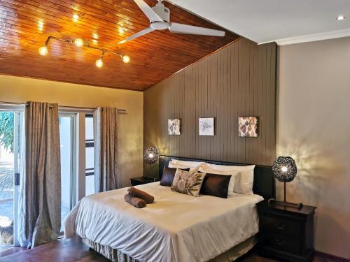 肯普顿帕克Aerotropolis Guest Lodge的一间卧室配有一张带吊扇的床
