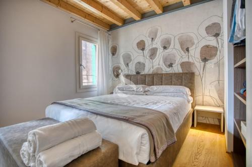 特雷维索Ca' dei Battuti Apartments的一间卧室配有一张床和壁画墙