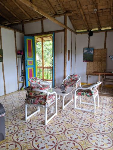 ChinchináHacienda Guayabal的一间房间,配有三把椅子、一张桌子和一扇门