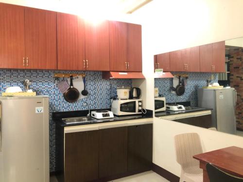 马尼拉Your City•Home Apartment的厨房配有木制橱柜和冰箱。