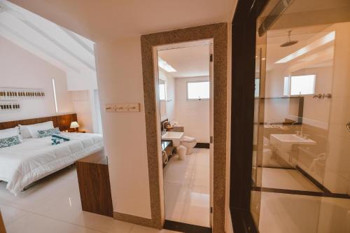 布希奥斯Maravista Hotel & Spa Ltda的一间卧室配有一张床,浴室设有水槽