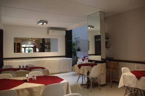 布宜诺斯艾利斯阿尔皮诺酒店的餐厅设有桌椅和镜子