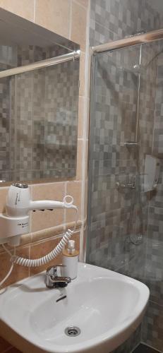 桑托尼亚Pensión CASA LEÓN的浴室配有白色水槽和淋浴。