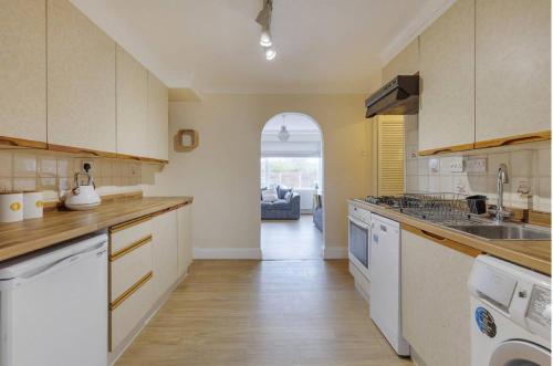 斯坦维尔Modern 4 bedroom house in Heathrow, London的厨房配有水槽和炉灶 顶部烤箱