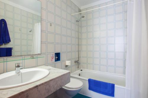 卡门港科斯塔玛尔公寓式酒店的浴室配有盥洗盆、卫生间和浴缸。
