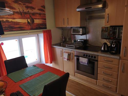 格蒙登Oranges Apartment的厨房配有桌子和炉灶。 顶部烤箱