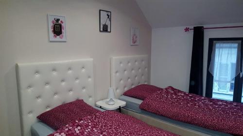 Beaumont-sur-Oise洛克公寓的一间卧室配有两张带红色枕头的床