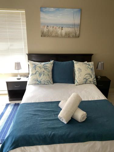 兰格班Sunset Heights的一张带蓝色毯子和枕头的床